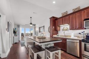 una cocina con armarios de madera y una gran isla de cocina en Baywatch C10 en Pensacola Beach