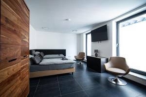 a bedroom with a bed and a desk and a chair at Blauer Stein 7a WH06 - Apartment Studio plus 1 SZ, 7Betten in Pulheim