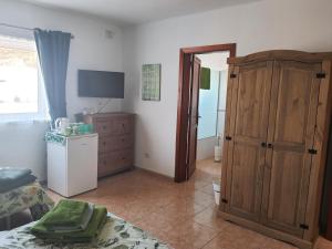 1 dormitorio con 1 cama, vestidor y TV en Villa Feliza, en Güime
