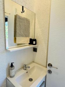 La salle de bains est pourvue d'un lavabo et d'un miroir. dans l'établissement Athena Tiny House, à Bodrum City