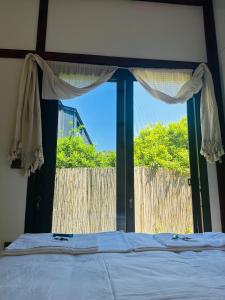 Schlafzimmer mit einem großen Fenster und einem Bett in der Unterkunft Athena Tiny House in Bodrum City