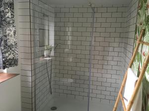uma casa de banho com um chuveiro com paredes em azulejos brancos em Charmante Unterkunft ohne Küche in Niestetal bei Kassel em Niestetal
