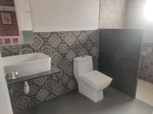 a bathroom with a white toilet and a sink at Ammara Eco Stays in Avathi +27 photos
