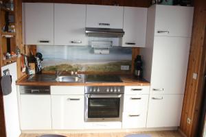 a kitchen with white cabinets and a sink at Us nige Wark - Familienfreundliches Haus an der Nordsee in Spieka-Neufeld +5 photos