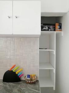 a kitchen with white cabinets and a basket of toys at Ticia Apartment in Chipata