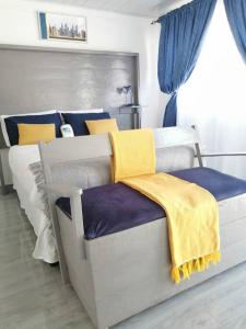 a bedroom with a bed with blue and yellow blankets at Ticia Apartment in Chipata