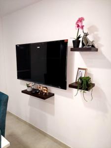 a flat screen tv hanging on a white wall at Apartamento en condominio con piscina in Villavicencio