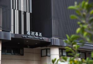 een gebouw met een uithangbord aan de zijkant bij Autumn Willow Hotel in Taichung