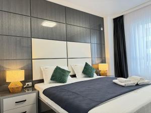 a bedroom with a large bed with green and white pillows at Luxury Glam Apartments Central Adress Bucuresti with Parking in Bucharest