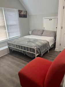 een slaapkamer met een bed en een rode bank bij Room near the beach in long branch in Long Branch