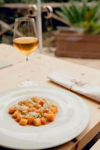 a white plate of food and a glass of wine at Villa Parri Residenza D'epoca in Pistoia