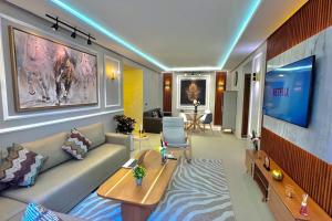 uma sala de estar com um sofá e uma televisão em E4 Luxury Appartement La Corniche Rabat - Essabah em Rabat