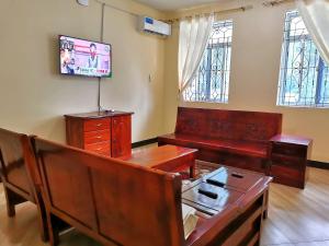 uma sala de estar com uma mesa e uma televisão em Sinthia Hotel Apartments em Chaki Chaki
