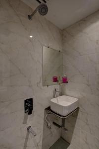 een badkamer met een witte wastafel en een spiegel bij Hotel Golden Palace Residency in Mumbai
