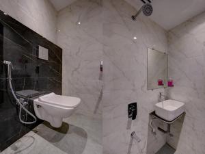 a bathroom with a white toilet and a sink at Hotel Golden Palace Residency in Mumbai