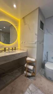 uma casa de banho com um lavatório, um WC e um espelho. em E4 Luxury Appartement La Corniche Rabat - Essabah em Rabat