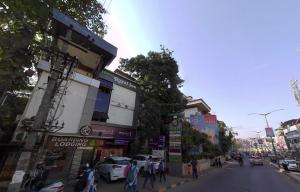 eine belebte Stadtstraße mit Leuten, die auf der Straße laufen in der Unterkunft Hotel Royal Inn Mangalore - Opp SDM Law College MG Road in Mangaluru