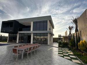 a building with a table and benches in front of it at ايله - Aylah 