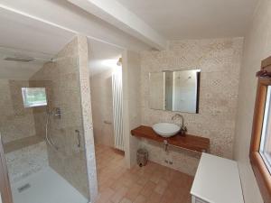 スペッロにあるPietra Rosaのバスルーム(シンク、鏡付きシャワー付)