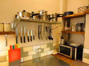 a kitchen with utensils hanging on a wall at Designer Maisonette Whole Apartment in Brighton & Hove