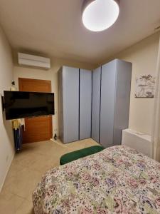 a bedroom with a bed and a flat screen tv at Novoli Chic: Cuore di Firenze in Florence