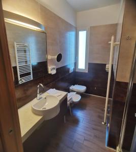 La salle de bains est pourvue d'un lavabo, de toilettes et d'un miroir. dans l'établissement Hotel Valdor, à Cavallino-Treporti