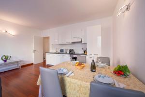 盧加諾的住宿－Sunlight，厨房以及带桌椅的用餐室。