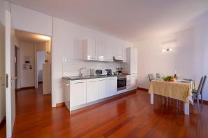 a kitchen with white cabinets and a table in a room at Sunlight in Lugano