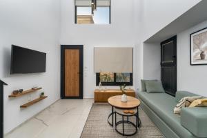 un soggiorno con un divano verde e un tavolo di Aelia Elegant Apartments a Kalamáta