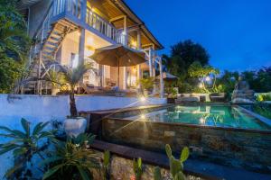 a house with a swimming pool in front of a house at The Puncak Private Villa in Nusa Lembongan