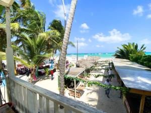 un balcón con vistas a una playa con palmeras y al océano. en CARAIBICO STUDIOS Beach Club & Pool, en Punta Cana