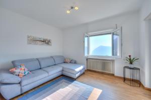 un soggiorno con divano blu e finestra di Ca' Gina Panoramica a Lugano