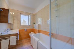 y baño con bañera, lavamanos y ducha. en Ca' Gina Panoramica, en Lugano
