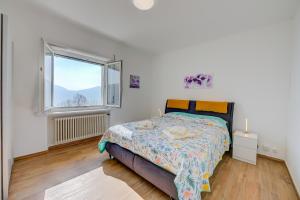 a bedroom with a bed and a window at Ca' Gina Panoramica - Monte Brè - Happy Rentals in Lugano