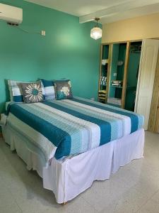 a bedroom with a large bed with blue walls at Taste Of Freedom in Brighton Village