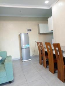 Il comprend une cuisine équipée d'un réfrigérateur, d'une table et de chaises. dans l'établissement Kigali Grand Villa, à Kigali