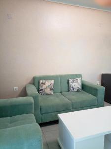 a living room with a green couch and a table at Kigali Grand Villa in Kigali