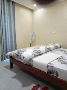 a bedroom with two beds and a fan at Kigali Grand Villa in Kigali