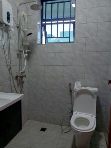 a bathroom with a shower and a toilet and a sink at Kigali Grand Villa in Kigali