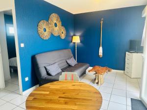a living room with a couch and a wooden table at Le chant des vagues in Frontignan
