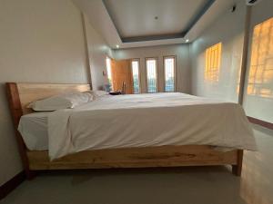 a bedroom with a large bed with white sheets at FOUR-G HOMESTAY & Komodo Tour in Labuan Bajo