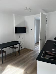 a kitchen with a desk and a table in a room at Stays by ADM in Leiden