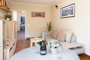 a living room with a table with a bottle of wine at Al Pontile Di Caslano - Happy Rentals in Caslano