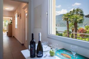 a table with two bottles of wine and glasses at Al Pontile Di Caslano - Happy Rentals in Caslano