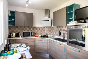 a kitchen with wooden cabinets and a tv on the wall at Al Pontile Di Caslano - Happy Rentals in Caslano