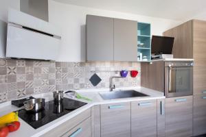 a kitchen with white cabinets and a sink at Al Pontile Di Caslano - Happy Rentals in Caslano