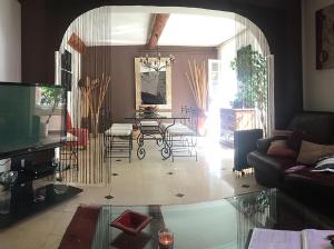 sala de estar con mesa de cristal y sillas en La Cigaline, en Laure-Minervois