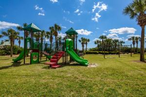 un parque infantil con tobogán en un parque con palmeras en St. Lucia 704, en Destin