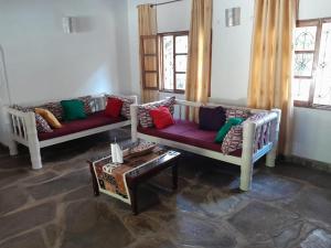 een woonkamer met 2 banken en een tafel bij Lion Garden Villa 7 in Malindi