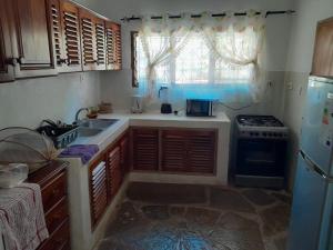 een keuken met een wastafel en een fornuis bij Lion Garden Villa 7 in Malindi